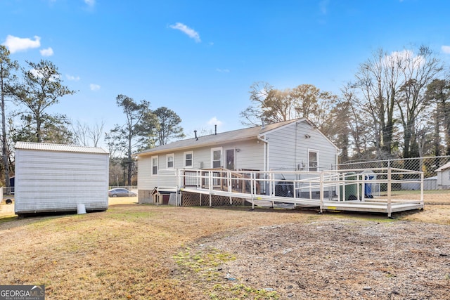 rear view of house featuring a deck and a yard