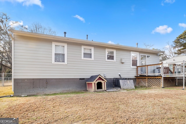 back of property with a lawn and a wooden deck