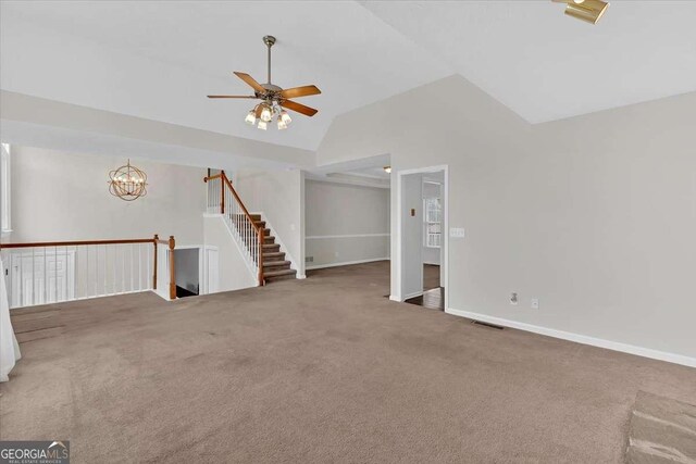 interior space featuring ceiling fan with notable chandelier, carpet floors, and high vaulted ceiling