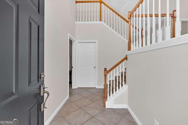 tiled entrance foyer with a towering ceiling