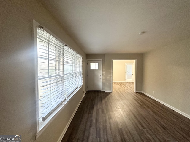 empty room with dark hardwood / wood-style flooring