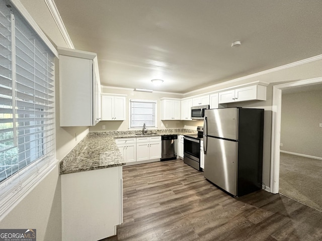 kitchen featuring stainless steel appliances, white cabinetry, a wealth of natural light, and sink