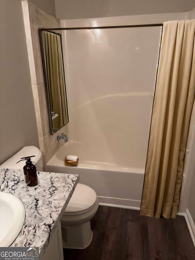 full bathroom featuring wood-type flooring, vanity, toilet, and shower / bath combo with shower curtain