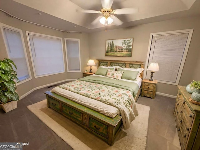 bedroom featuring carpet floors, a tray ceiling, and ceiling fan