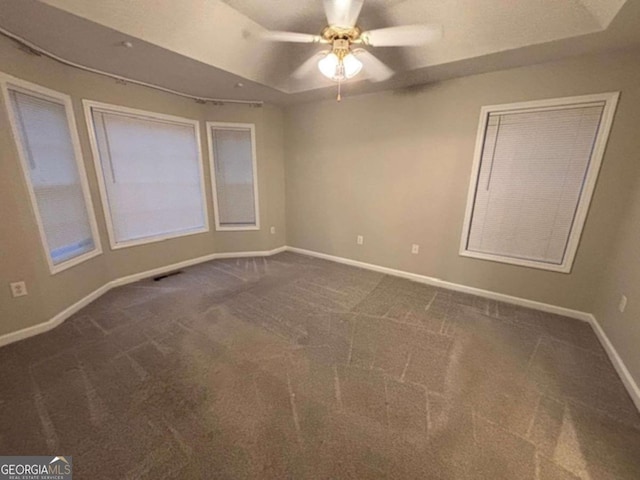 spare room featuring ceiling fan and carpet