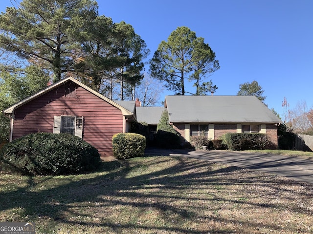 view of side of home with a yard