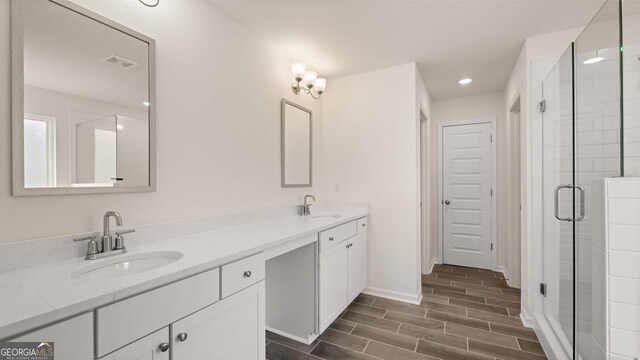 bathroom with vanity and a shower with shower door