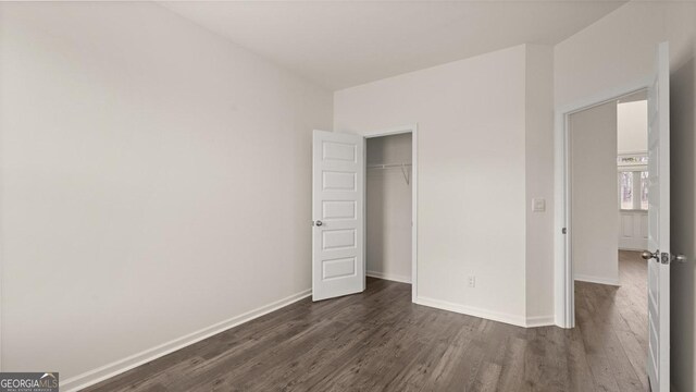 unfurnished bedroom with dark hardwood / wood-style floors and a closet