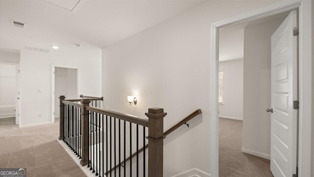 hallway featuring light colored carpet