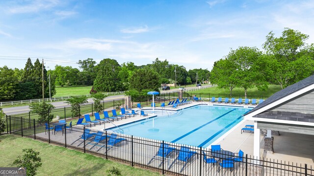 view of swimming pool with a lawn and a patio