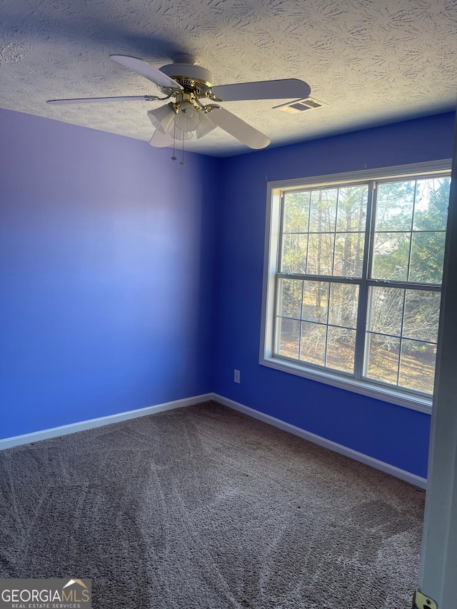 spare room featuring carpet, ceiling fan, and a textured ceiling