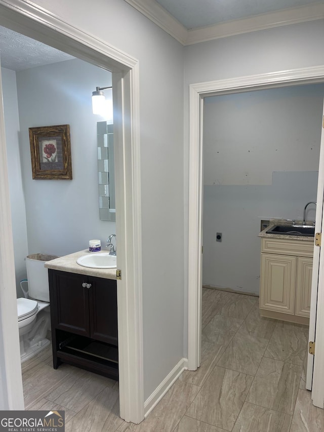 bathroom featuring vanity, toilet, and ornamental molding