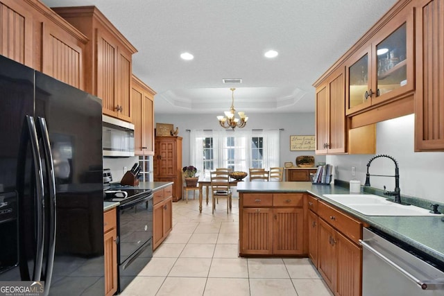 kitchen with pendant lighting, an inviting chandelier, black appliances, a raised ceiling, and sink