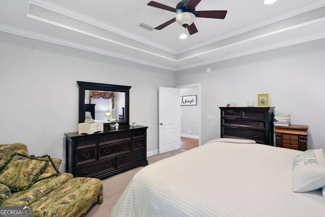 carpeted bedroom featuring a raised ceiling, ceiling fan, and ornamental molding