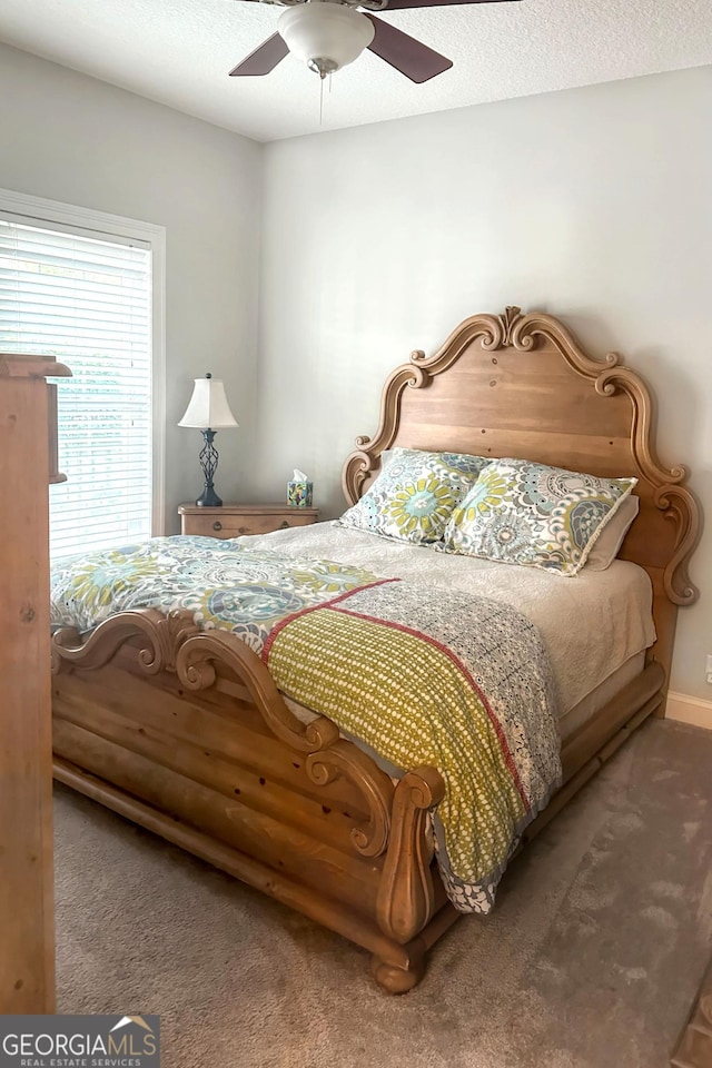 bedroom with ceiling fan, carpet, and a textured ceiling