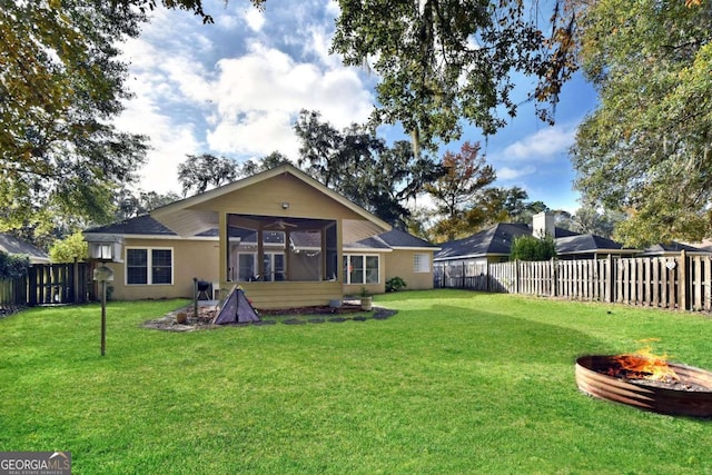 rear view of house with a yard and ceiling fan