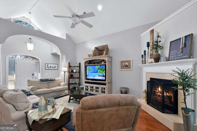 living room with plenty of natural light, a high end fireplace, wood-type flooring, and high vaulted ceiling