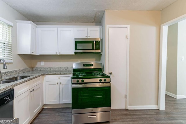 kitchen with sink, white cabinets, dark hardwood / wood-style floors, and appliances with stainless steel finishes