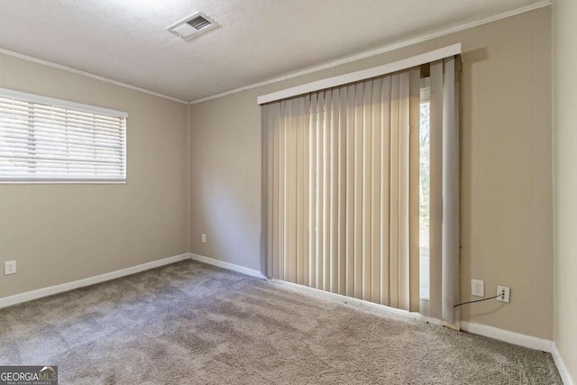 carpeted empty room with a textured ceiling and crown molding