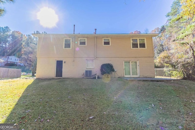 rear view of property with a yard and central AC unit