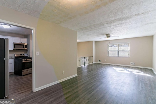 unfurnished living room with a textured ceiling, dark hardwood / wood-style floors, and ceiling fan