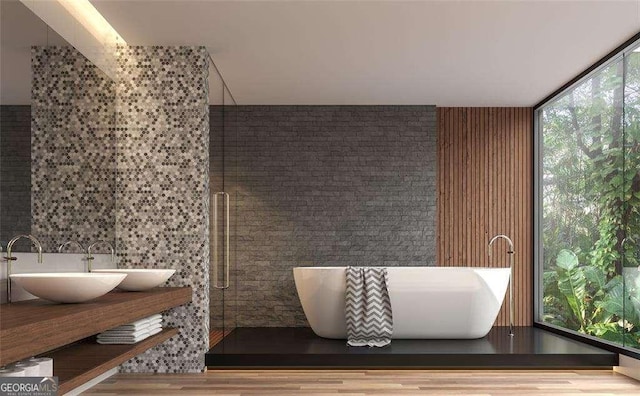 bathroom with hardwood / wood-style floors, a washtub, floor to ceiling windows, and vanity