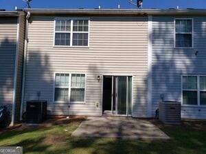 rear view of house with a lawn, central AC, and a patio area