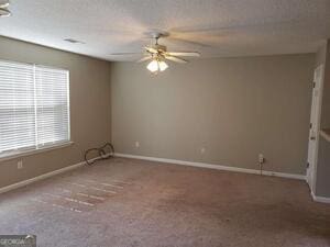 empty room featuring carpet flooring and ceiling fan