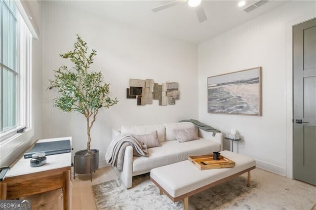 living area with ceiling fan and light hardwood / wood-style flooring