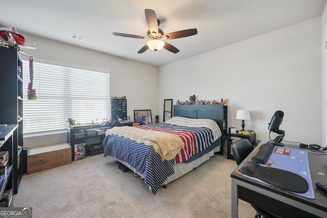 carpeted bedroom with ceiling fan and multiple windows