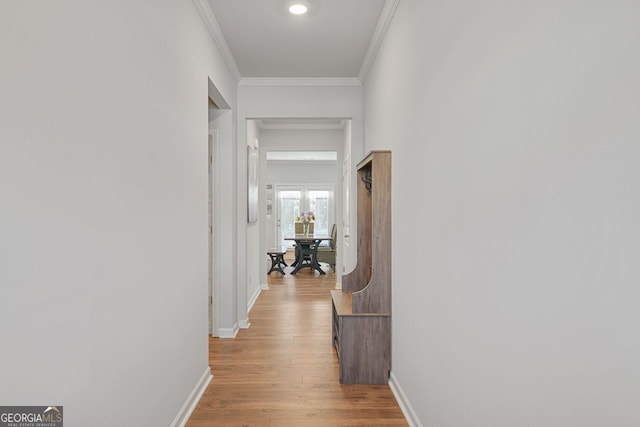 corridor featuring light hardwood / wood-style floors and crown molding