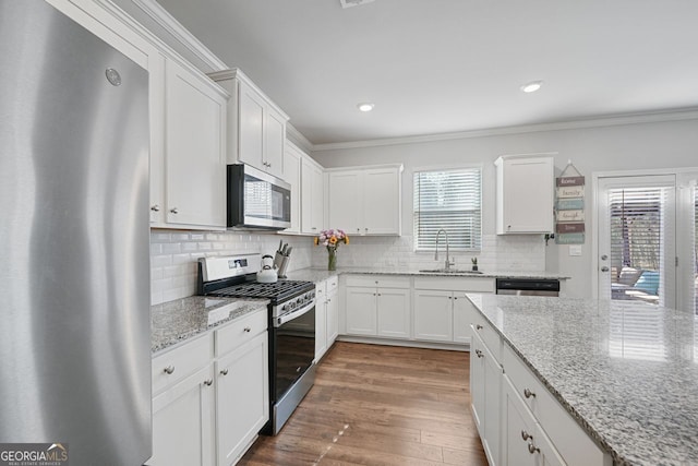 kitchen featuring light stone countertops, sink, white cabinets, and appliances with stainless steel finishes