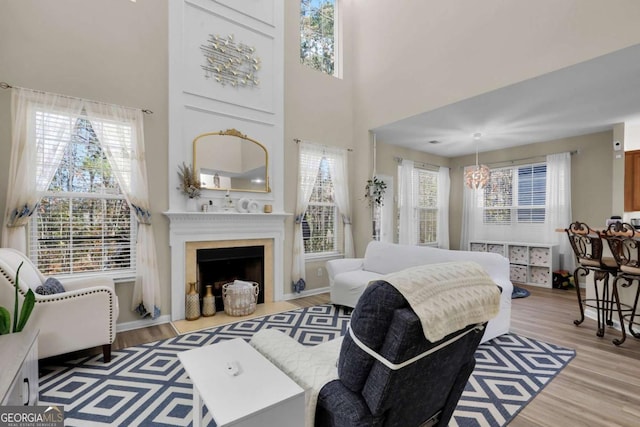 bedroom with light hardwood / wood-style flooring, a towering ceiling, and an inviting chandelier