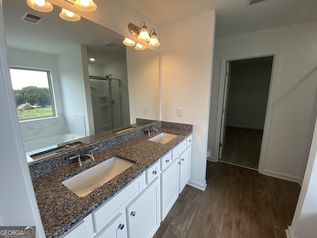 bathroom featuring hardwood / wood-style floors, vanity, and shower with separate bathtub