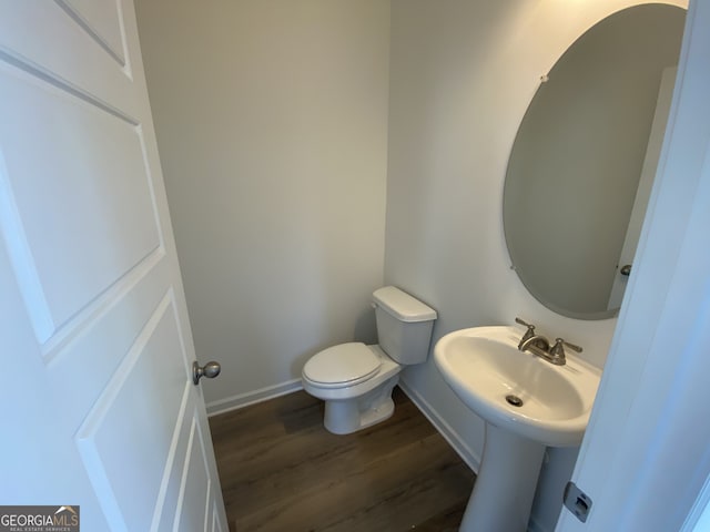 bathroom with hardwood / wood-style floors, toilet, and sink