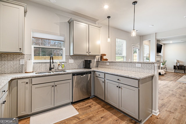 kitchen with gray cabinetry, dishwasher, sink, light hardwood / wood-style flooring, and pendant lighting