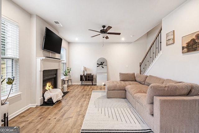 living room with ceiling fan and light hardwood / wood-style flooring