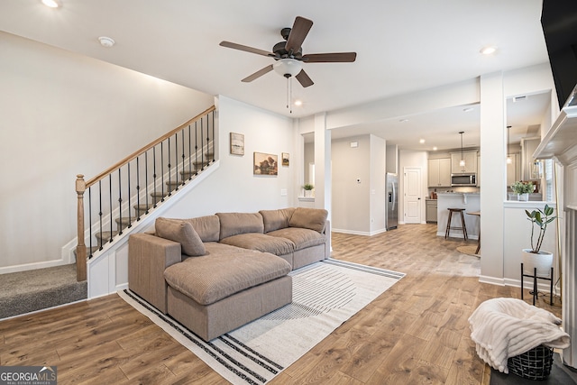 living room with ceiling fan and light hardwood / wood-style flooring