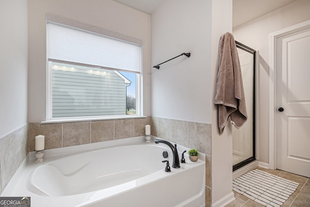 bathroom with tile patterned floors and shower with separate bathtub