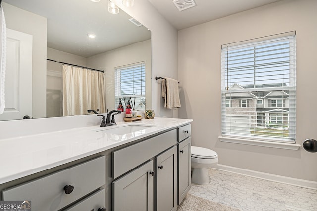 bathroom featuring tile patterned floors, vanity, curtained shower, and toilet