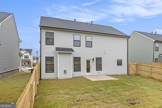 back of house featuring a patio area and a lawn