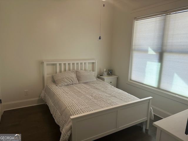 bedroom with dark wood-type flooring