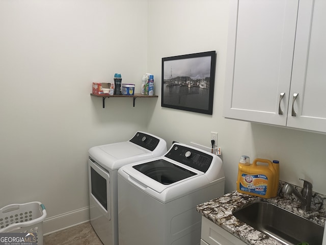 laundry area featuring cabinets, independent washer and dryer, and sink