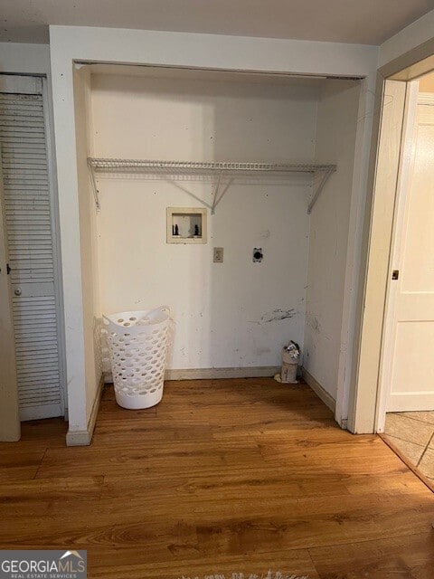 clothes washing area featuring electric dryer hookup, washer hookup, laundry area, and light wood finished floors