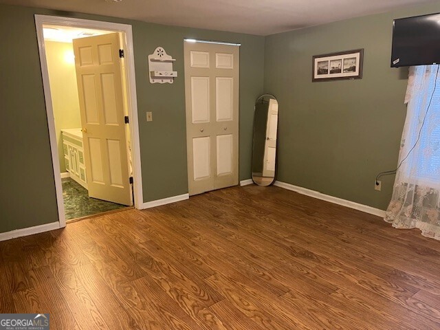 unfurnished bedroom with baseboards and wood finished floors