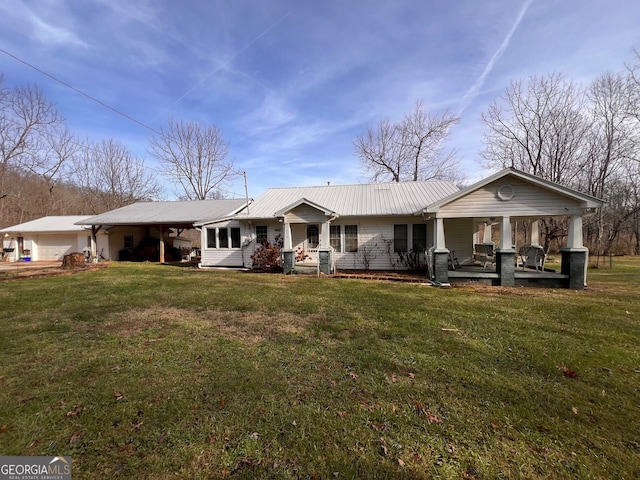 back of property with a porch, a lawn, and metal roof