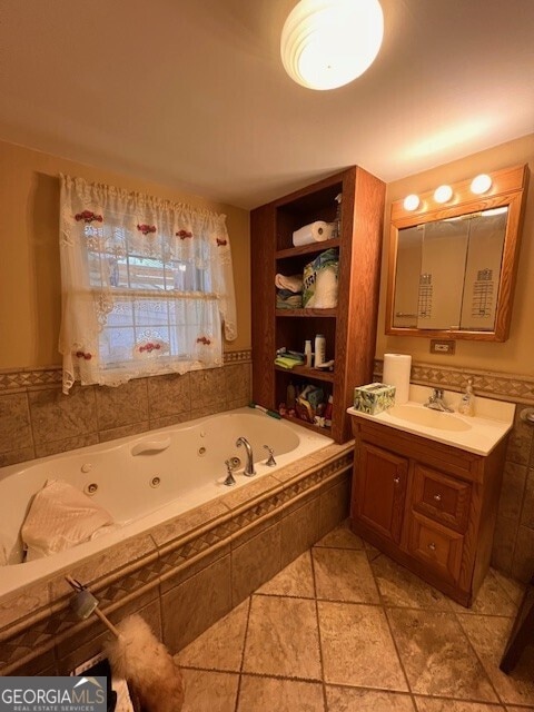 full bath with vanity and a tub with jets