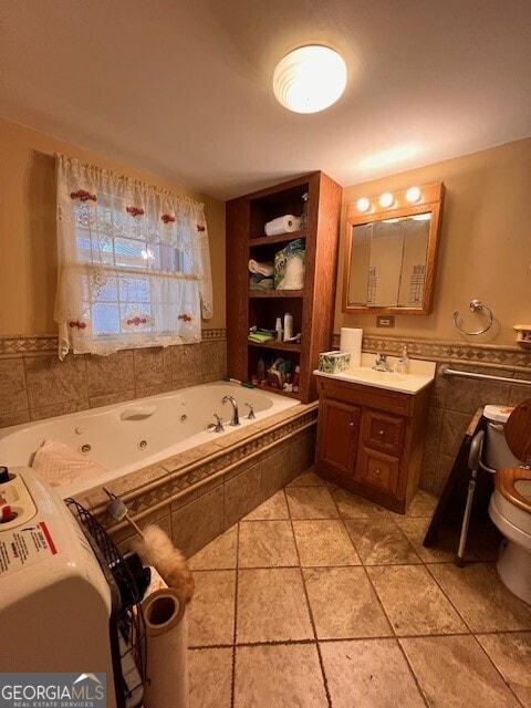 full bath with vanity, a tub with jets, wainscoting, tile walls, and toilet