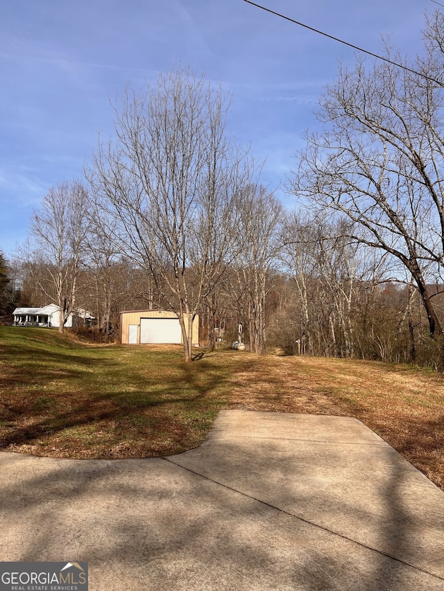 view of yard featuring an outbuilding, driveway, and a garage