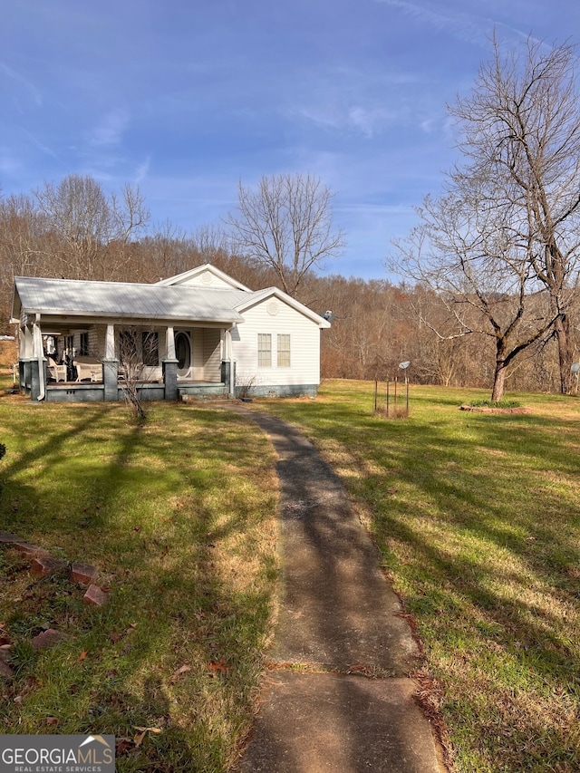 bungalow featuring covered porch, metal roof, and a front yard